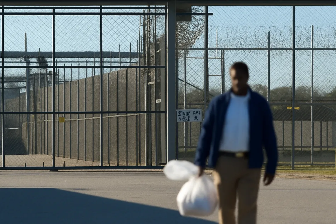 A man carrying his belongings, walking free past the gate on his release day
